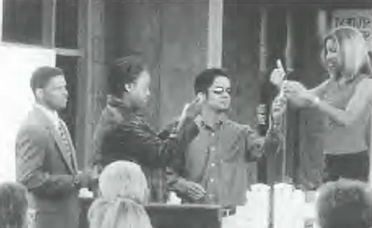 A group of people st和 for a presentation in front of a building, black 和 white photo